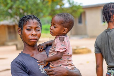 Foto de Abuja, Nigeria - 1 de mayo de 2023: Retrato de una madre y un niño africanos. Random Candid Moments with African Children. Feliz niño africano. Día del Niño en África. - Imagen libre de derechos