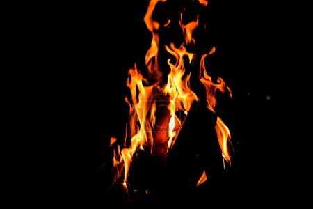 Foto de Fuego de campamento. Bon Fire brillando por la noche al aire libre con chispas. Fuego Naranja-Amarillento sobre un Fondo Negro - Imagen libre de derechos