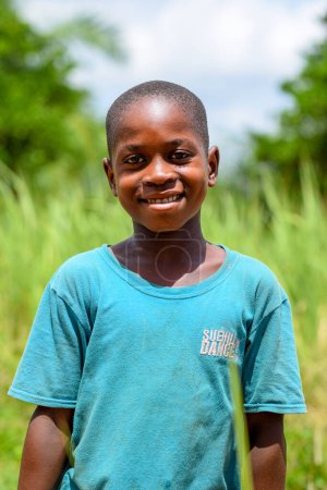 Photo for Abuja, Nigeria - June 12, 2023: Portrait of african school boy posing on the background of green grass - Royalty Free Image