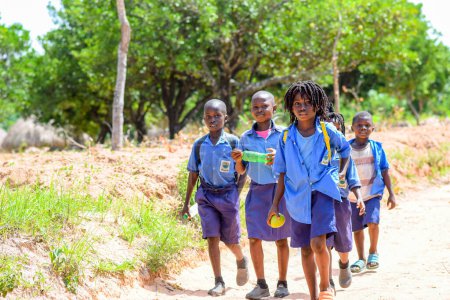 Foto de Abuja, Nigeria - 12 de junio de 2023: Aprendizaje de jóvenes niños africanos en una comunidad rural. Niños africanos sonrientes con uniforme escolar. Educación en África. - Imagen libre de derechos
