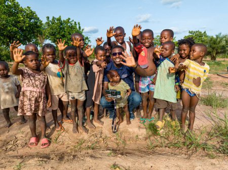 Téléchargez les photos : Abuja, Nigéria - 12 juin 2023 : Groupe d'enfants africains posant sur un drone et criant bonjour - en image libre de droit