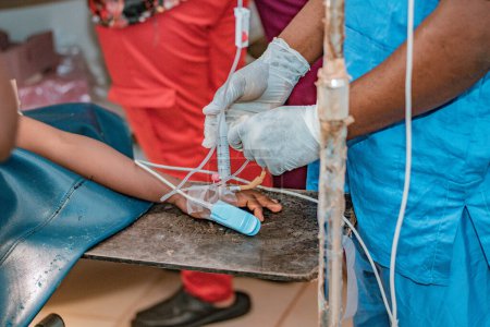 Téléchargez les photos : Abuja Nigeria - 06 février 2021 : Le chirurgien africain et les membres de son équipe préparent le patient à une procédure chirurgicale - en image libre de droit
