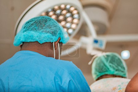 Téléchargez les photos : Abuja Nigeria - 06 février 2021 : Le chirurgien africain et les membres de son équipe préparent le patient à une procédure chirurgicale - en image libre de droit