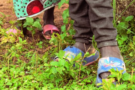 Foto de Nigeria - 20 de junio de 2023: pies de niños africanos con sandalias calzado, primer plano - Imagen libre de derechos