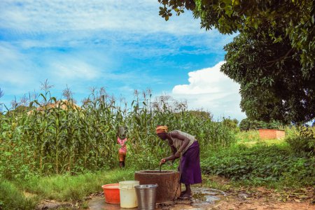 Photo for Nigeria - June 20, 2023: woman fetching water from water well in African village - Royalty Free Image