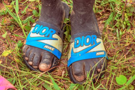 Téléchargez les photos : Nigeria - 20 juin 2023 : Pieds de gamin africain portant des tongs chaussures, gros plan - en image libre de droit