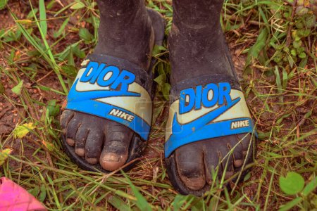 Photo for Nigeria - June 20, 2023: feet of African kid wearing flip-flops footwear, closeup - Royalty Free Image