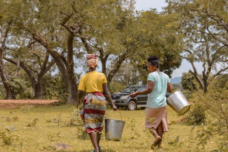 Foto de Abuja, Nigeria - 8 de octubre de 2022: Africans Fetching Water. Solución de agua limpia en la comunidad africana - Imagen libre de derechos