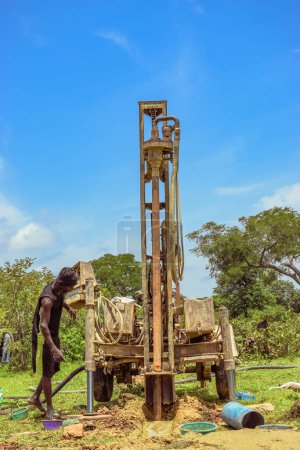 Téléchargez les photos : Jos East, État du Plateau, Nigéria - 12 mai 2021 : Processus de forage de l'eau dans une communauté africaine avec des équipements mécanisés. Machine de forage Projet d'eau rurale. - en image libre de droit