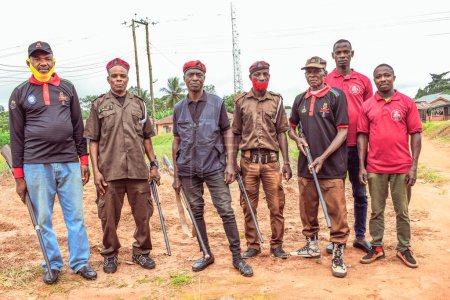 Téléchargez les photos : Nigeria - 20 juin 2023 : groupe d'hommes militaires armés debout dans un village africain - en image libre de droit