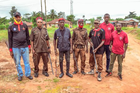 Téléchargez les photos : Nigeria - 20 juin 2023 : groupe d'hommes militaires armés debout dans un village africain - en image libre de droit