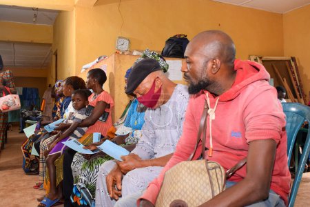 Téléchargez les photos : Abuja, Nigeria - 20 décembre 2021 : Africains assis en attente d'une file d'attente pour des soins médicaux gratuits et de l'attention dans une communauté rurale. - en image libre de droit