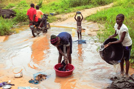 Foto de Delta State, Nigeria - 9 de diciembre de 2021: Mujeres africanas lavando ropa en el río, Nigeria - Imagen libre de derechos