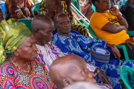 Foto de Abuja, Nigeria - 20 de diciembre de 2021: Africanos sentados esperando una cola para recibir atención médica gratuita y atención en una comunidad rural. - Imagen libre de derechos