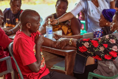 Foto de Abuja, Nigeria - 30 de enero de 2023: Consulta al paciente africano en una aldea. Sesión de asesoramiento individual con un terapeuta en una comunidad local. - Imagen libre de derechos