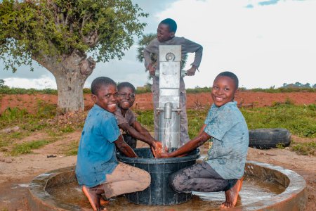Photo for Abuja, Nigeria - August 02, 2021: African Children Having Fun as they Express Happiness and Laughter while Playing with Clean Water under the Sun in a Rural Community. Joyful and Grateful Children - Royalty Free Image