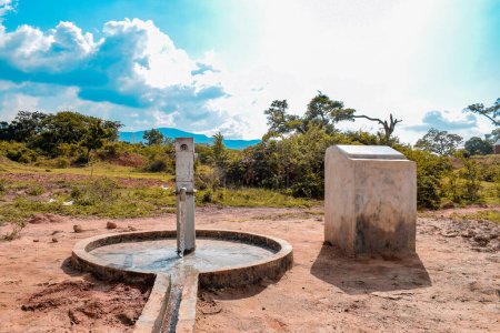 Téléchargez les photos : Karara, État de Nasarawa, Nigéria - 5 mai 2021 : Vue à 360 degrés d'un puits de forage de pompe à main indien nouvellement construit dans une communauté rurale en Afrique. Eau courante provenant d'un point d'eau de forage communautaire - en image libre de droit