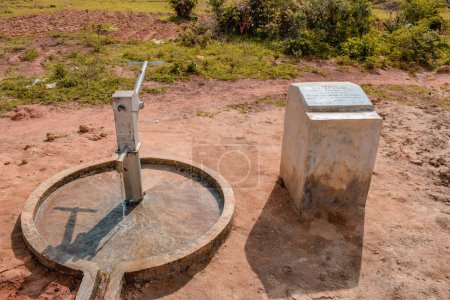 Téléchargez les photos : Karara, État de Nasarawa, Nigéria - 5 mai 2021 : Vue à 360 degrés d'un puits de forage de pompe à main indien nouvellement construit dans une communauté rurale en Afrique. Eau courante provenant d'un point d'eau de forage communautaire - en image libre de droit