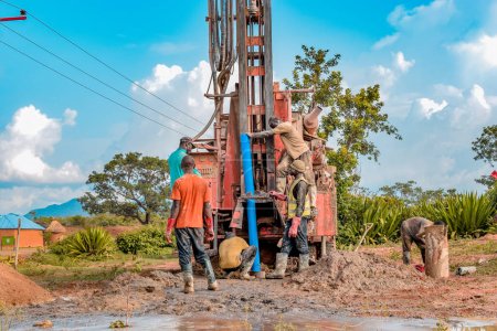 Foto de Jos East, Plateau State - 12 de mayo de 2021: Proceso de perforación de agua en una comunidad africana con equipos mecanizados. Perforadora Proyecto Agua Rural. - Imagen libre de derechos