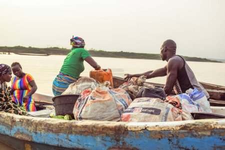 Téléchargez les photos : Delta State, Nigeria - 9 décembre 2021 : Utilisation du transport par eau dans les communautés africaines. Utilisation commerciale des rivières africaines. Achats et ventes en milieu rural. Pêche dans les villages africains. - en image libre de droit