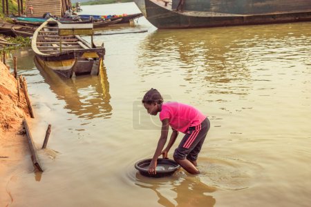 Photo for Delta State, Nigeria - December 9, 2021: African girl taking Unclean and Contaminated Water from a Pond or Stream for Daily Consumption in Africa - Royalty Free Image