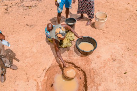 Téléchargez les photos : Jos East, État du Plateau, Nigéria - 12 mai 2021 : Des Africains récupèrent de l'eau impure et contaminée d'un étang ou d'un ruisseau pour leur consommation quotidienne - en image libre de droit