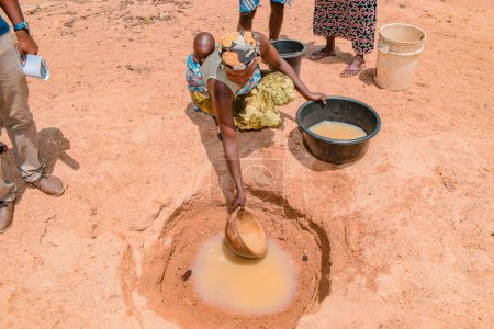 Téléchargez les photos : Jos East, État du Plateau, Nigéria - 12 mai 2021 : Des Africains récupèrent de l'eau impure et contaminée d'un étang ou d'un ruisseau pour leur consommation quotidienne - en image libre de droit