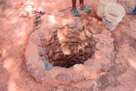 Foto de Mano seca excavada bien en una comunidad rural. Agua cruda sin tratar Muddy - Imagen libre de derechos