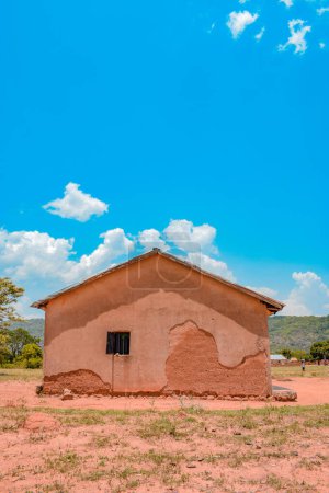 Téléchargez les photos : Jos East, État du Plateau - 12 mai 2021 : Clinique rurale africaine typique sous le beau ciel bleu un après-midi ensoleillé. Bâtiment local de boue d'argile pour la résidence locale en Afrique. - en image libre de droit