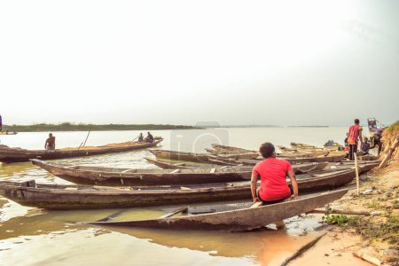 Foto de Delta State, Nigeria - 9 de diciembre de 2021: Uso del Transporte de Agua en Comunidades Africanas. Uso comercial de African Rivers. Compra y Venta en el Medio Rural. Pesca en aldeas africanas. - Imagen libre de derechos