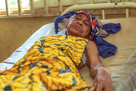 Téléchargez les photos : État d'Edo, Nigéria - 25 décembre 2021 : Femme africaine se rétablissant au lit dans une clinique rurale après une chirurgie réussie - en image libre de droit