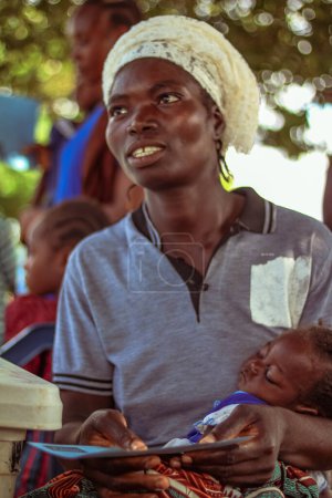 Foto de Abuja, Nigeria - 1 de abril de 2023: Retrato de un niño africano con madre. Momentos francos al azar con niños africanos - Imagen libre de derechos