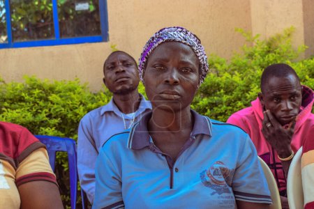 Foto de Estado de Edo, Nigeria - 10 de agosto de 2021: Africanos sentados, haciendo cola y esperando atención médica gratuita en una comunidad rural - Imagen libre de derechos