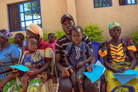 Téléchargez les photos : État d'Edo, Nigéria - 10 août 2021 : Africains assis, faisant la queue et attendant des soins médicaux gratuits dans une communauté rurale - en image libre de droit