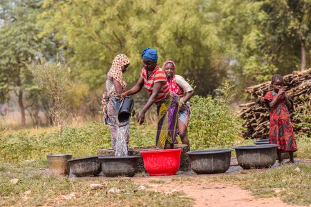 Téléchargez les photos : Abaji, FCT Abuja - 20 janvier 2023 : Une Africaine récupère de l'eau d'un puits creusé à la main dans une communauté rurale. - en image libre de droit