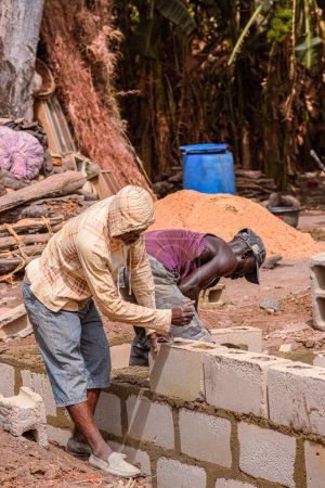 Téléchargez les photos : Abaji, FCT Abuja - 20 janvier 2023 : Bâtiment Construction d'un appartement de 3 chambres dans une communauté rurale. Des bricoleurs travaillant sur un chantier. - en image libre de droit
