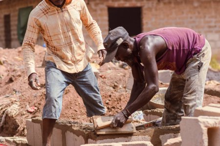 Foto de Abaji, FCT Abuja - 20 de enero de 2023: Construcción de un apartamento de 3 dormitorios en una comunidad rural. Artesanos trabajando en una obra de construcción. - Imagen libre de derechos