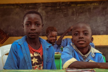 Téléchargez les photos : Abuja, Nigéria - 6 juin 2022 : Portrait d'un enfant africain apprenant dans une communauté rurale. Enfants africains souriants portant l'uniforme scolaire dans une salle de classe. Enseignement primaire dans les villages africains. - en image libre de droit
