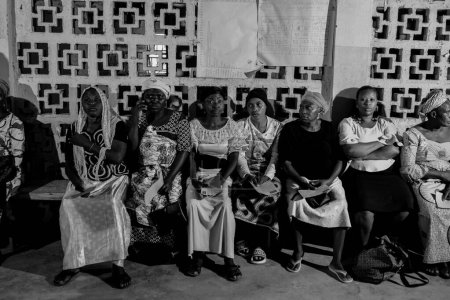 Foto de Bauchi, Plateau State - 10 de junio de 2022: Africanos sentados, haciendo cola y esperando atención médica gratuita en una comunidad rural. La gente se registra para votar en las elecciones. Ejercicio de campaña política - Imagen libre de derechos