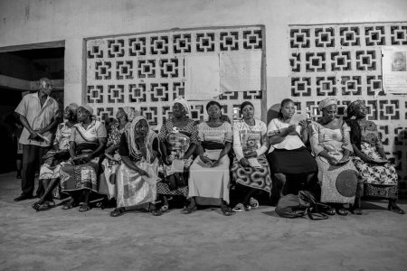 Foto de Bauchi, Plateau State - 10 de junio de 2022: Africanos sentados, haciendo cola y esperando atención médica gratuita en una comunidad rural. La gente se registra para votar en las elecciones. Ejercicio de campaña política - Imagen libre de derechos