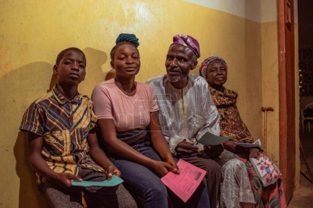 Téléchargez les photos : Bauchi, État du Plateau - 10 juin 2022 : Africains assis, faisant la queue et attendant des soins médicaux gratuits et de l'attention dans une communauté rurale. Les gens s'inscrivent pour voter aux élections. Exercice de campagne politique - en image libre de droit