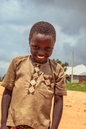 Foto de Plateau State, Nigeria - 5 de junio de 2022: Retrato de un niño africano. Momentos francos al azar con el niño africano al aire libre - Imagen libre de derechos