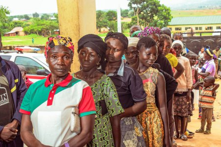 Foto de Bauchi, Plateau State - 10 de junio de 2022: Africanos haciendo cola y esperando atención médica gratuita en una comunidad rural. La gente se registra para votar en las elecciones. Ejercicio de campaña política - Imagen libre de derechos