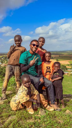 Téléchargez les photos : Jos, Nigéria - 2 avril 2023 : Homme africain avec des enfants dans un village - en image libre de droit