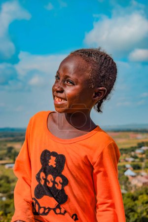 Téléchargez les photos : État du Plateau, Nigéria - 5 juin 2022 : Portrait d'un enfant africain. Moments de franchise aléatoires avec enfant africain en plein air sur un ciel bleu ensoleillé. - en image libre de droit