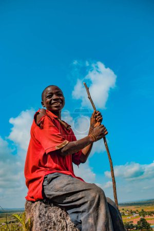 Foto de Plateau State, Nigeria - 5 de junio de 2022: Retrato de un niño africano. Momentos francos al azar con un niño africano al aire libre en un cielo azul soleado. - Imagen libre de derechos