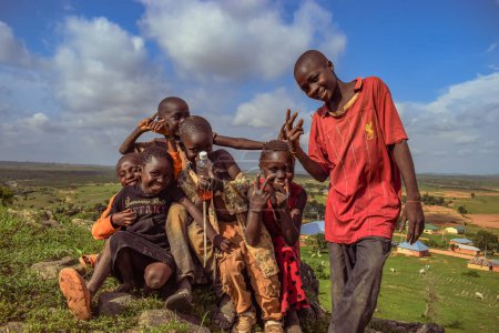 Foto de Plateau State, Nigeria - 6 de octubre de 2022: Niños africanos se divierten. Momentos tontos con niños africanos locales al aire libre bajo un soleado cielo azul. - Imagen libre de derechos