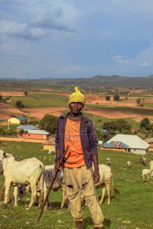 Foto de Plateau State, Nigeria - 5 de junio de 2022: Retrato de un adolescente africano pastando vacas - Imagen libre de derechos