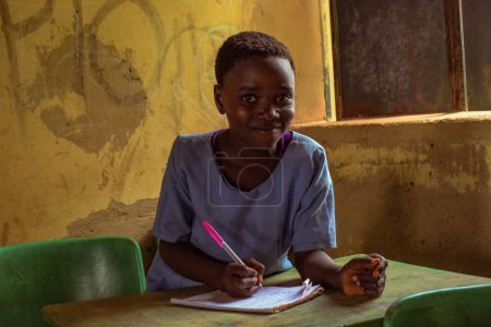 Téléchargez les photos : Abuja, Nigéria - 6 juin 2022 : Portrait d'un enfant africain apprenant dans une communauté rurale. Enfants africains souriants portant l'uniforme scolaire dans une salle de classe. Enseignement primaire dans les villages africains - en image libre de droit