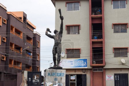 Téléchargez les photos : Enugu, État d'Enugu - 06 mai 2021 : Statue d'un cri de ville à un rond-point majeur entouré de bâtiments Storey Jonction d'Obiagwu - en image libre de droit